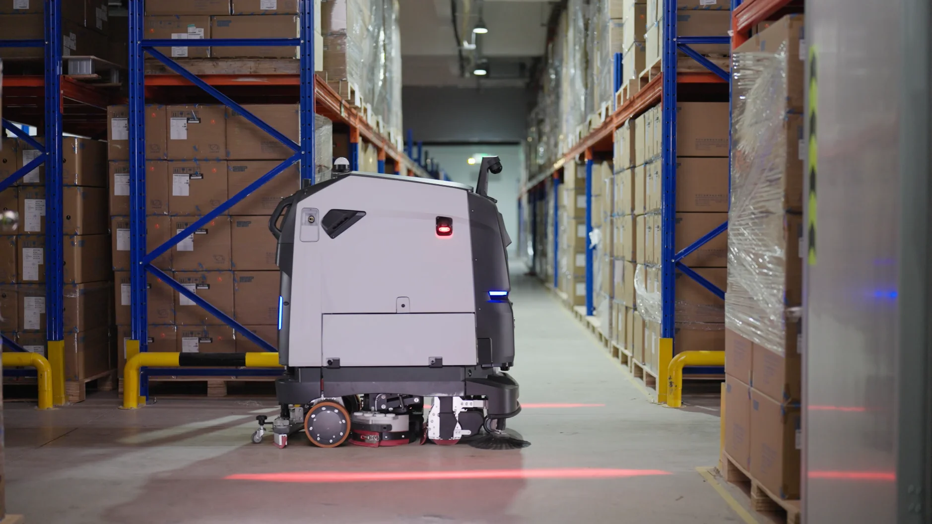 Robot de nettoyage dans une allée d’entrepôt